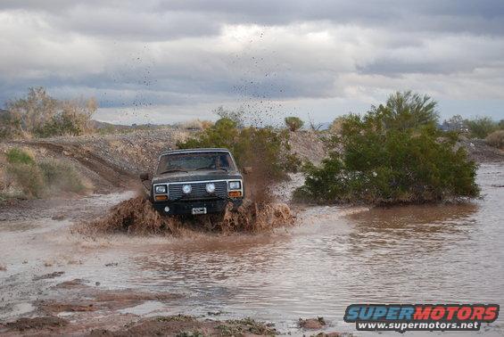 Jeep Cherokee XJ driving through mud and splashing water