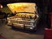 1973 Ford F-100 - A 1973 Ford F-100 truck sits in a garage with its hood raised, showing the engine compartment.