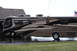 2003 Ford F-350 - A large motorhome is parked on a wet driveway next to a house, with an American flag visible in the background.