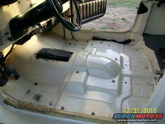 1986 Jeep interior floor stripped down, showing pedals, steering column, and transmission tunnel