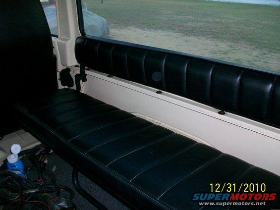 Vehicle interior showing black vinyl bench seat and padded side panel. Wires are visible under the seat. Date stamp reads 12/31/2010