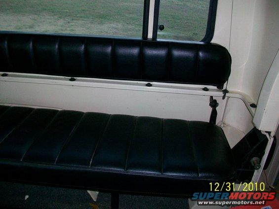 Back bench seat inside a vehicle, black vinyl with white trim