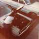 1968 Mercury Cougar - A person attends to the engine bay of a car, with a second vehicle visible in the background.