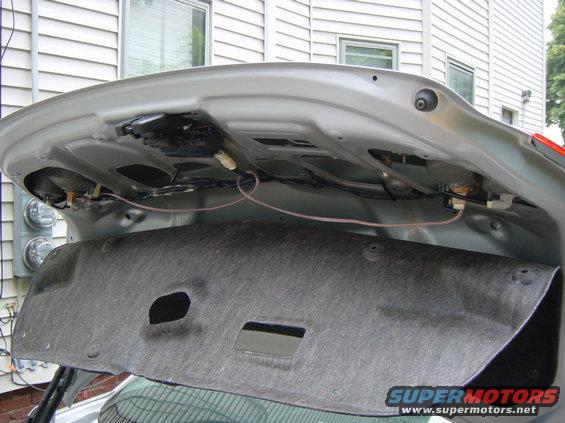 Silver car trunk interior with wiring and insulation panel removed