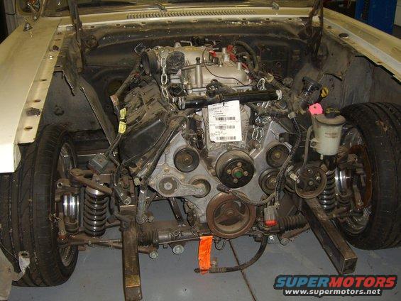 Car engine and front suspension assembly, with chains holding the engine