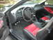 2003 Ford Mustang - The interior of a 2003 Ford Mustang features two-tone red and black seats and a manual transmission.