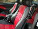 2003 Ford Mustang - Interior view of a 2003 Ford Mustang Cobra, red and black seats with the Cobra emblem.