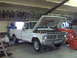 1973 Ford F-100 - White 1973 Ford F-100 pickup truck with hood open, on jack stands, in a garage.