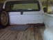 1973 Ford F-100 - Rear view of a white 1973 Ford F-100 pickup truck bed, showing the interior and a spare tire.