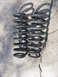 1994 Ford Bronco - A pair of black coil springs are shown on a concrete surface.