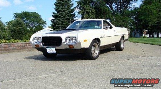 White 1970s pickup truck with black hood accent and chrome wheels