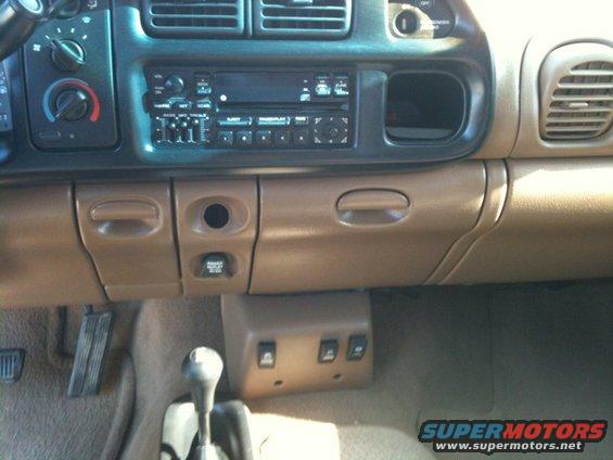 Interior view of a vehicle's dashboard, showing the radio, climate controls, gear shifter, and center console