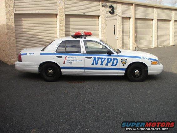 White 2002 Ford Crown Victoria police car with NYPD markings, side view