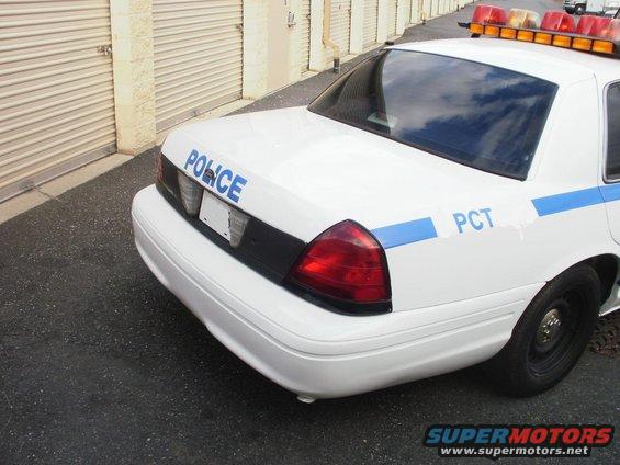 White 2002 Ford Crown Victoria police car, rear quarter view, with "POLICE" and "PCT" markings