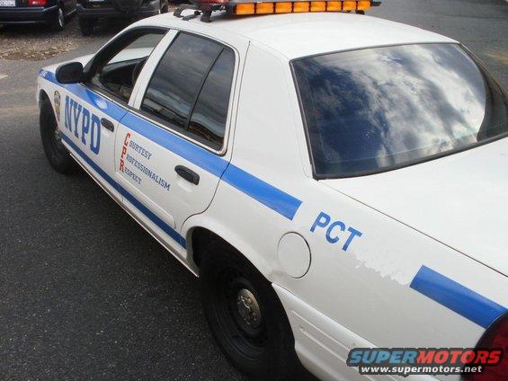 NYPD police car with blue stripe and "PCT" marking on rear quarter panel