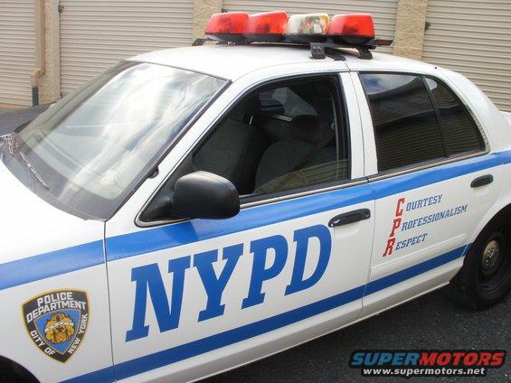 NYPD police car with blue stripe and "NYPD" text. Also shows "POLICE DEPARTMENT CITY OF NEW YORK" badge and "COURTESY PROFESSIONALISM RESPECT" text