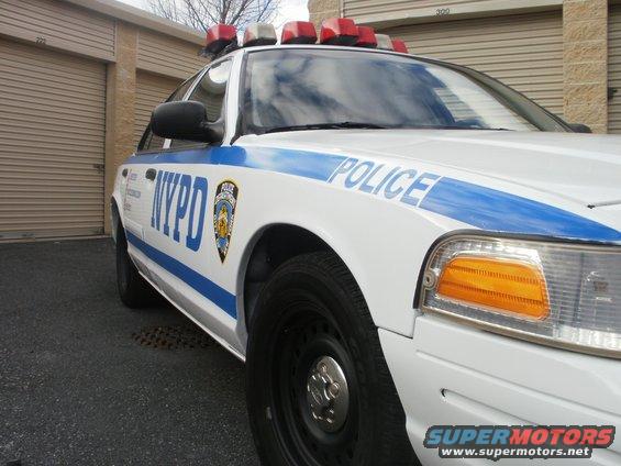 NYPD police car, front quarter view. It has a light bar on top and 'POLICE' text on the side