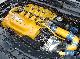 Close-up of yellow and blue engine component with silver accents