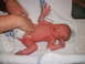 1989 Ford Bronco - A newborn baby is being attended to on a white blanket.