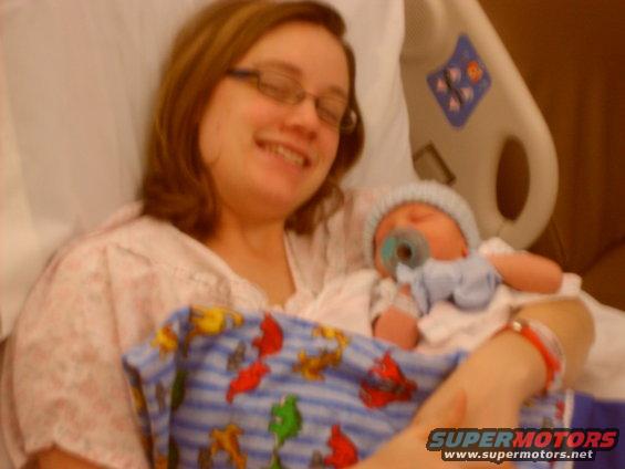 Woman holding a newborn baby with a pacifier