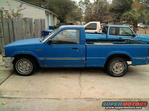 1987 Mazda B2200 pickup truck, side view. Another truck is parked behind it