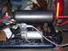 1991 Ford Bronco - An air compressor and tank are installed in the bed of a truck, connected by red hoses.