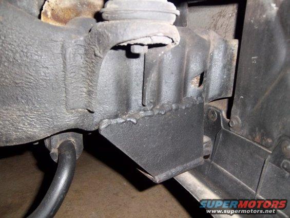 Close-up of a welded suspension bracket on a vehicle's undercarriage