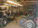 1995 Ford Bronco - Camouflaged 1995 Ford Bronco undergoing work in a garage, surrounded by tools and spare tires.