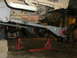 1995 Ford Bronco - Vehicle is on jack stands with aftermarket suspension parts visible on the rear axle.