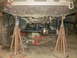 1995 Ford Bronco - The underside of a vehicle is elevated on jack stands, revealing its suspension components and differential for maintenance or modification.