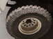 1971 International School Bus - A close-up view of a large off-road tire and wheel, the Supermotors logo at the bottom right.