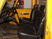 1971 International School Bus - The interior of a yellow truck shows black vinyl seats and a steering wheel, with a red toolbox visible.