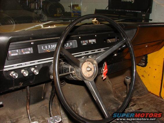 Interior dashboard with gauges and steering wheel of a yellow vehicle
