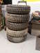 1971 International School Bus - A stack of five used off-road tires sits on a concrete floor in a garage.
