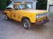 1971 International School Bus - A yellow International pickup truck is parked outside with a white truck behind it.