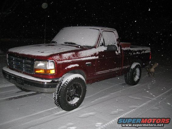 1996 Ford F-150 pickup truck covered in snow at night