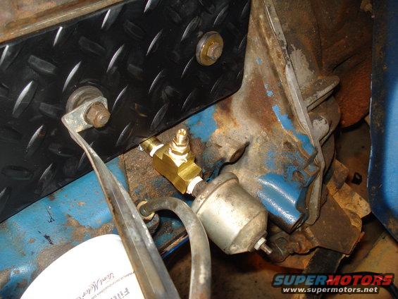 Engine oil filter with a brass T-fitting and plumbing. Part of a Ford Motor Company filter is visible