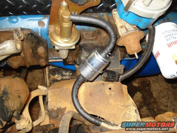 Engine fuel filter and fuel pump assembly with visible text on hoses