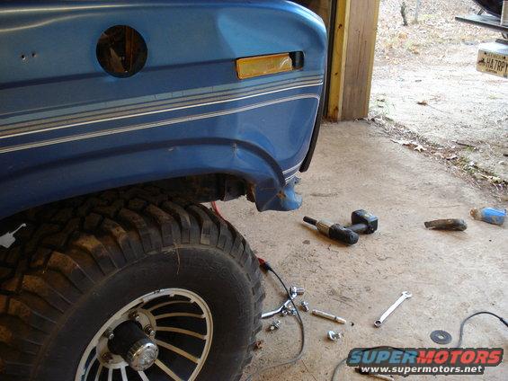 1985 Ford F-150 front fender and tire, with tools on the ground
