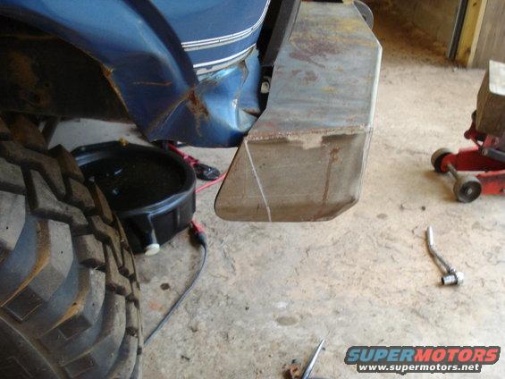 1985 Ford F-150 with custom metal bumper and large tire. Oil drain pan visible
