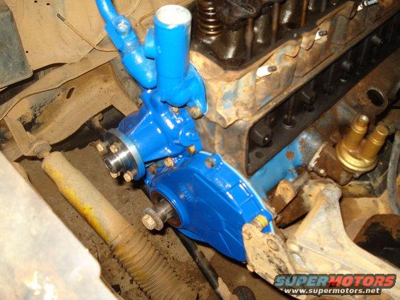 Blue painted engine component attached to a V8 engine block