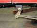 1984 Ford Bronco - Close-up of a suspension component attached to a red vehicle body, with a Supermotors.net logo visible.