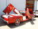 1956 Ford Fairlane - This custom convertible features gullwing doors and a white interior, with another vehicle visible in the background.