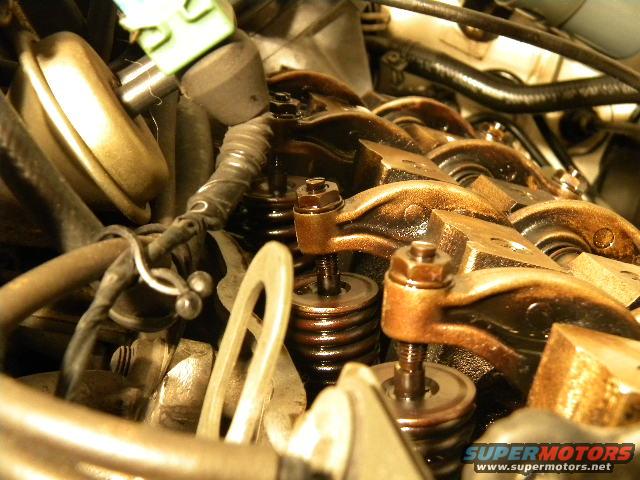 Engine valve train with oil, showing rocker arms and springs