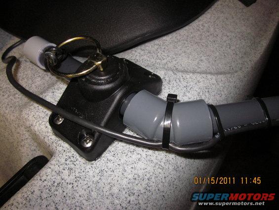 Kayak rigging with black plastic mount, metal ring, and gray tubing secured by zip ties