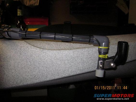 Kayak accessory mount with pipe and zip ties attached to the side of a kayak