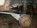 1995 Ford Bronco - Close-up view of a vehicle's suspension system, showing the brake assembly and coil spring.