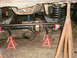 1995 Ford Bronco - Undercarriage view of a vehicle undergoing suspension work, supported by jack stands.