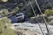 1991 Ford Bronco - A dark SUV with a roof rack is shown off-roading on a steep, rocky trail.