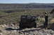 1991 Ford Bronco - A modified off-road vehicle navigates a rocky, desert landscape with a person celebrating nearby.